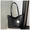 Dettaglio della borsa tote in pelle nera con un portachiavi a mostro soffice e trama fine - Con Ciondolo / Nero