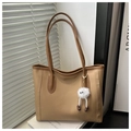 Dettaglio della borsa tote in pelle kaki con cuciture marroni e ciondolo a mostro bianco - Con Ciondolo / Cachi