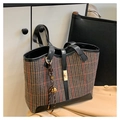 Detail of vintage plaid tweed tote bag with leather straps and gold twist lock on trench coat - With Charm / Brown