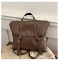 Detail view of the vintage brown leather backpack with silver metal buckles and top handle - Coffee