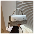 Close-up of silver crossbody bag with textured checkerboard pattern and glossy finish - Silver