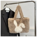 Dettaglio della borsa tote in peluche marrone con motivo a coniglio bianco su stampella - Cachi