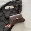 Donkerbruine crossbodytas met krokodillenreliëf, gebogen basis en gouden gesp - Bruin