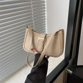Chic beige leather shoulder bag with gold clasp shown in a minimalist indoor setting - Khaki