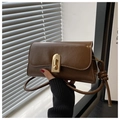Close-up of vintage dark brown baguette bag featuring a gold lock and knotted shoulder strap - Brown