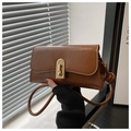 Detail of vintage brown leather bag with golden metal lock and stylish side knot strap - Brown