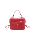 Red quilted box bag with top handle and gold camellia detail on a white background - Red