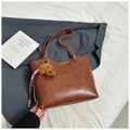 Detail of a brown tote bag with cute plush puppy charm and FASHION & BAGS embossing - With Ornament / Brown