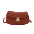 Minimalist brown pebbled leather crescent saddle bag with golden triangular metal clasp - Brown