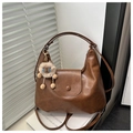 Detail van vintage bruine leren schoudertas met een schattige leeuw pluche hanger - Bruin (Met Hanger)