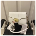 Close-up of white crocodile pattern shoulder bag with a gold twist lock and chain strap - White