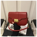 Detail of red croc-embossed shoulder bag with golden lock and chain on New Urban book - Red