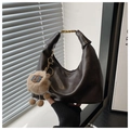 Detail of dark leather hobo bag with gold hardware and a cute sheep plush charm - Coffee with Pendant