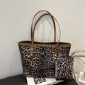 Large leopard print tote bag set with matching coin purse on a leather chair - Brown