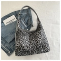 Detail van grote tote bag met luipaardprint gecombineerd met jeansjack en boeken - Zwart
