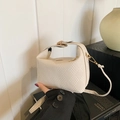 Beige gewebte Handtasche mit Karomuster und Gold-Schnalle in Lifestyle-Umgebung - Weiß