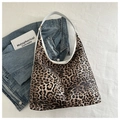Detail van luipaard hobo-tas met witte lederen riemen en denim jack op achtergrond - Bruin