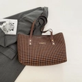 Classic brown houndstooth tote bag with leather handles on a grey suit jacket - Brown