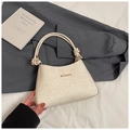 Detail of white lace embossed leather underarm bag with gold metal trim and knotted handle - White