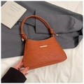 Detail of orange handbag with floral lace embossing and braided knot handle hardware - Brown
