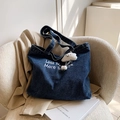 Large denim tote bag with embroidery on sofa, lifestyle casual shoulder bag view - Deep Blue-Less Mondays Embroidery (With Cloud Charm)