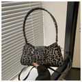 Detailed shot of leopard print baguette bag with dual straps in soft sunlight - Black