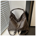 Detailed close-up of brown vintage leather tote bag with metallic hooks and straps - Coffee