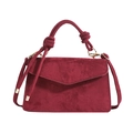 Minimalistische weinrote Wildledertasche mit Knotengriff und goldenen Details auf Weiß - Burgunderrot