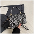 Close-up of leopard print shoulder bag with gold hardware and circular top handle - Black