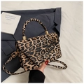 Detail shot of leopard print crossbody bag with golden hardware and round top handle - Khaki