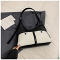 Detalle del bolso hobo de cuero negro con bolsillo de felpa blanca y botones negros - Negro