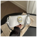 Detail of silver metallic handbag featuring a textured gold buckle and knotted strap - Silver