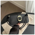 Macro detail of black leather shoulder bag featuring a vintage gold oval metal buckle - Black