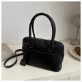 Dettaglio borsa Boston vintage nera con cuciture bianche su scrivania minimale - Nero
