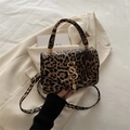 Borsa a tracolla leopardata con logo SS dorato e nappina su sfondo di un abito - Marrone Chiaro