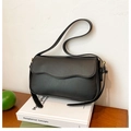 Detalle del bolso de hombro negro con solapa de borde ondulado y herrajes metálicos dorados - Negro