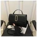 Détail d'un sac à main noir mat minimaliste avec une grande boucle en métal doré - Noir