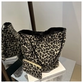 Dettaglio del set di borse in tela leopardata con bordi neri su una superficie riflettente - Nero