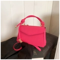 Détail du sac bandoulière tressé rose vif avec poignée nouée et finitions dorées - Rose