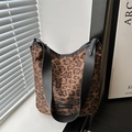 Große Shopper-Tasche mit Leopardenmuster und schwarzem Schultergurt auf Fensterbank - Braun
