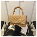 Detalle de bolso acolchado beige con borde metálico y asa fruncida de diseño suave - Caqui