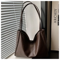 Detail of soft vintage dark brown faux leather tote bag texture and slim shoulder straps - Coffee