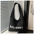 Detail of black canvas tote bag with white lettering and decorative ribbon bow - Black