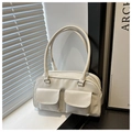 Detail view of cream white PU leather handbag with front flap pockets and long handles - White