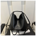Detalle del bolso tote de cuero negro con logotipo grabado y cremallera plateada - Negro