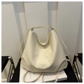 Detalle de bolso de hombro plisado crema con parche de logo en cuero sobre fondo - Blanco