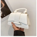 Detail of white lychee leather handbag featuring gold metal eyelets and top handle - White