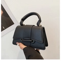 Detailed close-up of black lychee grain leather mini bag with gold hardware and top handle - Black