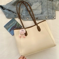 Bolso tote crema con ribete marrón y colgante de felpa rosa sobre fondo blanco - Con Colgante / Blanco Roto