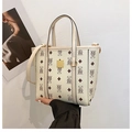 Detail der cremefarbenen Beuteltasche mit Bärendruck und braunem Rautenmuster - Weiß